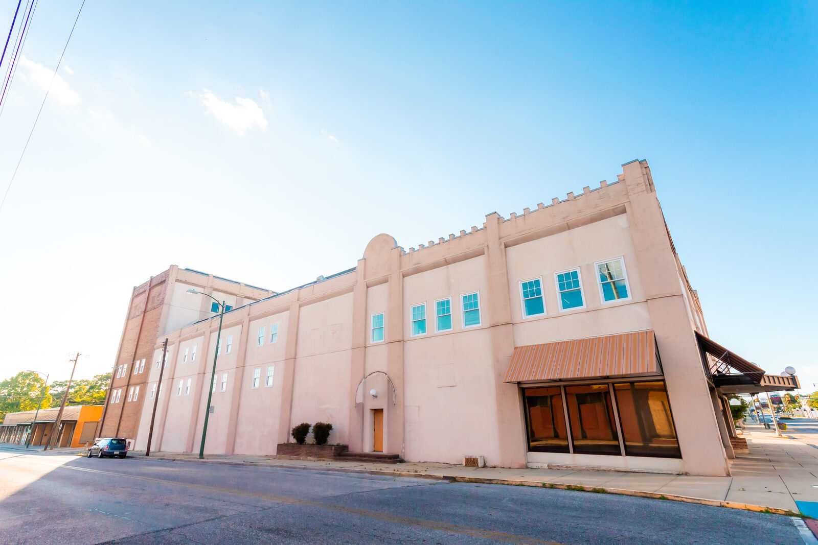 The full Lyric Square facade in daylight, with the historic LYRIC lettering above the storefronts on Noble Street in downtown Anniston, Alabama