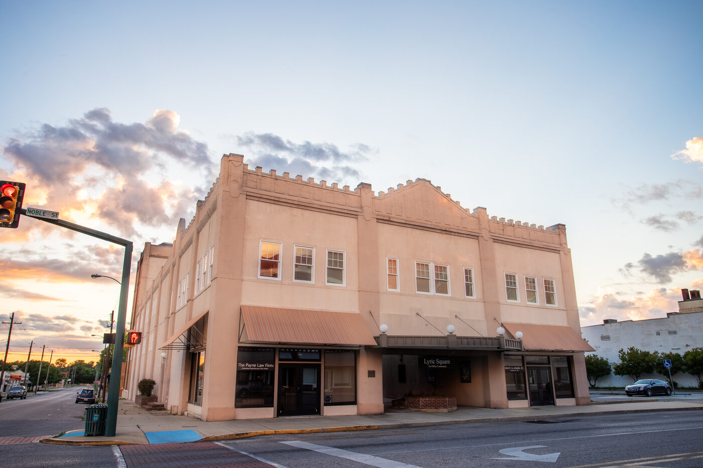 The historic Lyric Square building at dusk, 1302 Noble Street in downtown Anniston, Alabama, with the LYRIC sign lit against the evening sky